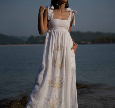 The Lace Coral Dress is composed of 100% European Linen, with beaded applique coral motifs. It offers a comfortable adjustable fit and features delicate applique with glass beads, and real natural baroque pearls on trims.