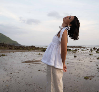 The Nori trousers are an elastic waisted 100% linen pant for a comfortable easy fit, with finishing including real natural pearl and gold plated charms at the end of the belt ties.  Embroidery designed by Fleur Kakasi at the hem. 
